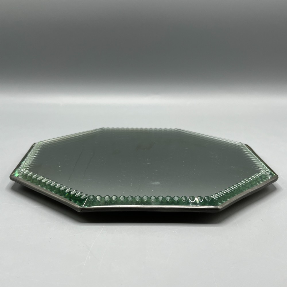 An octagonal frameless mirror featuring a decoratively cut bevelled interior border pattern on a clear mirrored surface. View XVIII