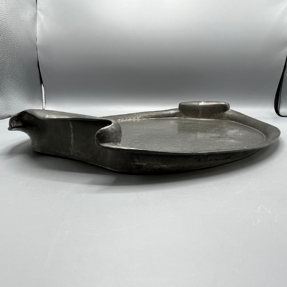 An oval pewter serving tray featuring a hand-hammered surface texture and raised integral handles on opposite ends. View VII