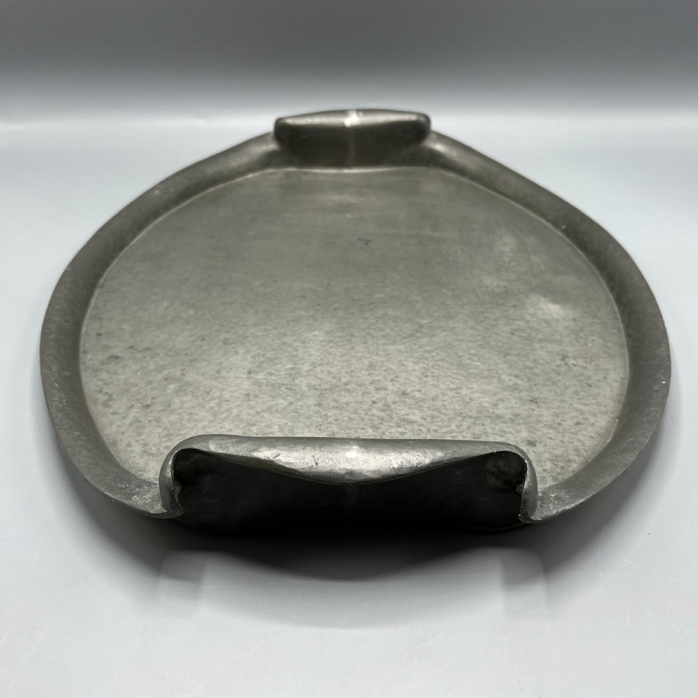An oval pewter serving tray featuring a hand-hammered surface texture and raised integral handles on opposite ends. View VIII
