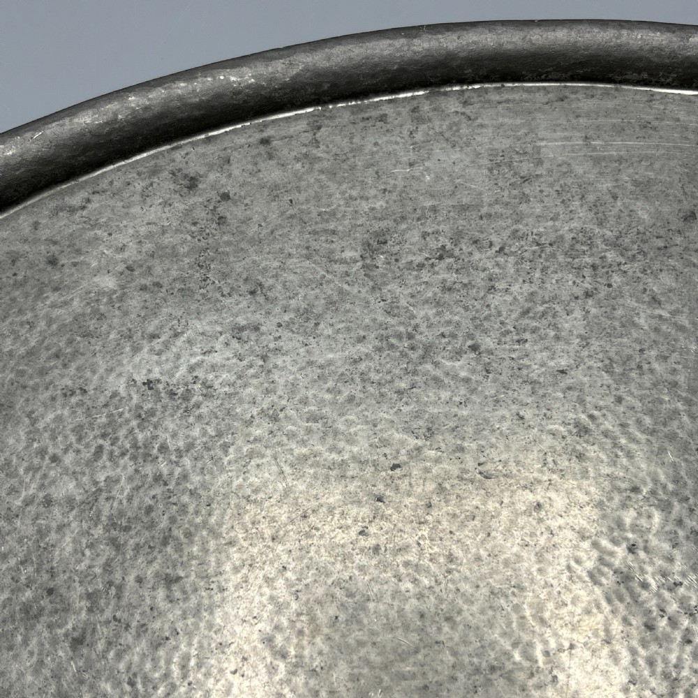 An oval pewter serving tray featuring a hand-hammered surface texture and raised integral handles on opposite ends. View XII