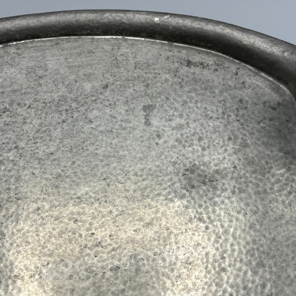 An oval pewter serving tray featuring a hand-hammered surface texture and raised integral handles on opposite ends. View XIII