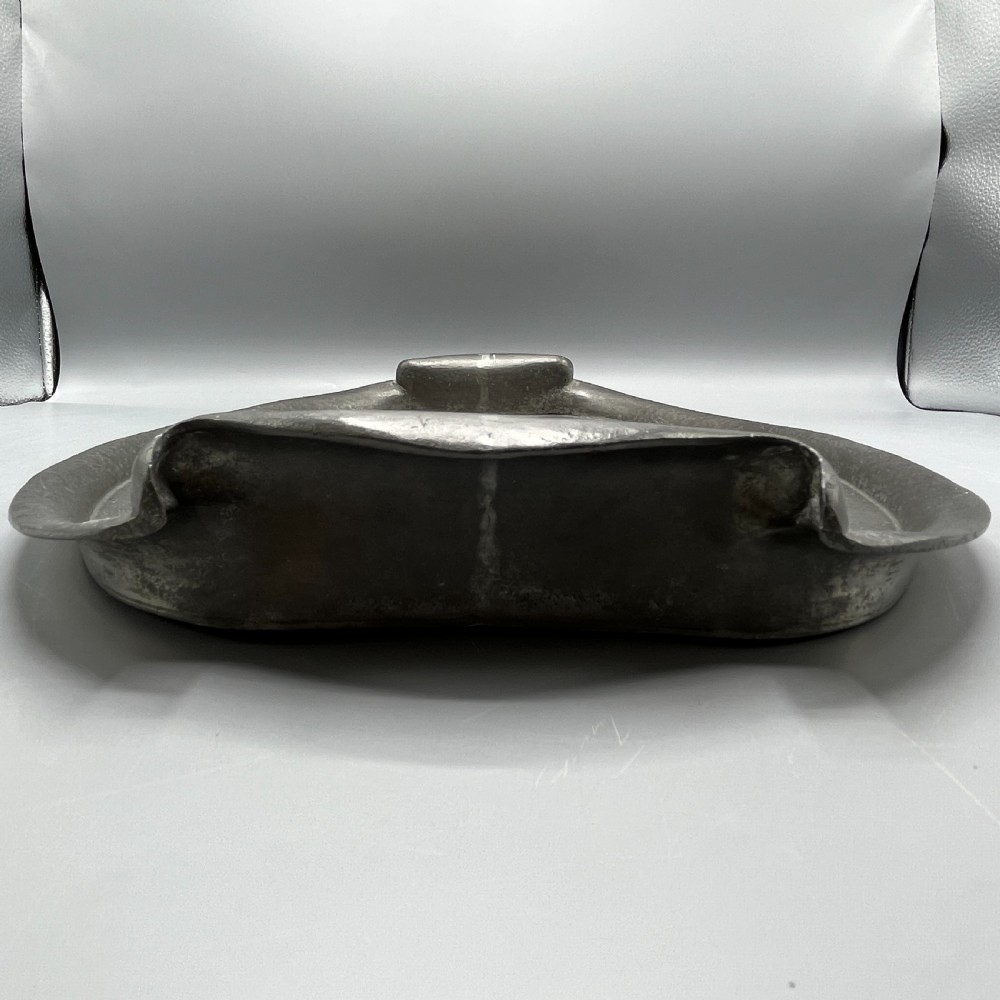 An oval pewter serving tray featuring a hand-hammered surface texture and raised integral handles on opposite ends. View XIX