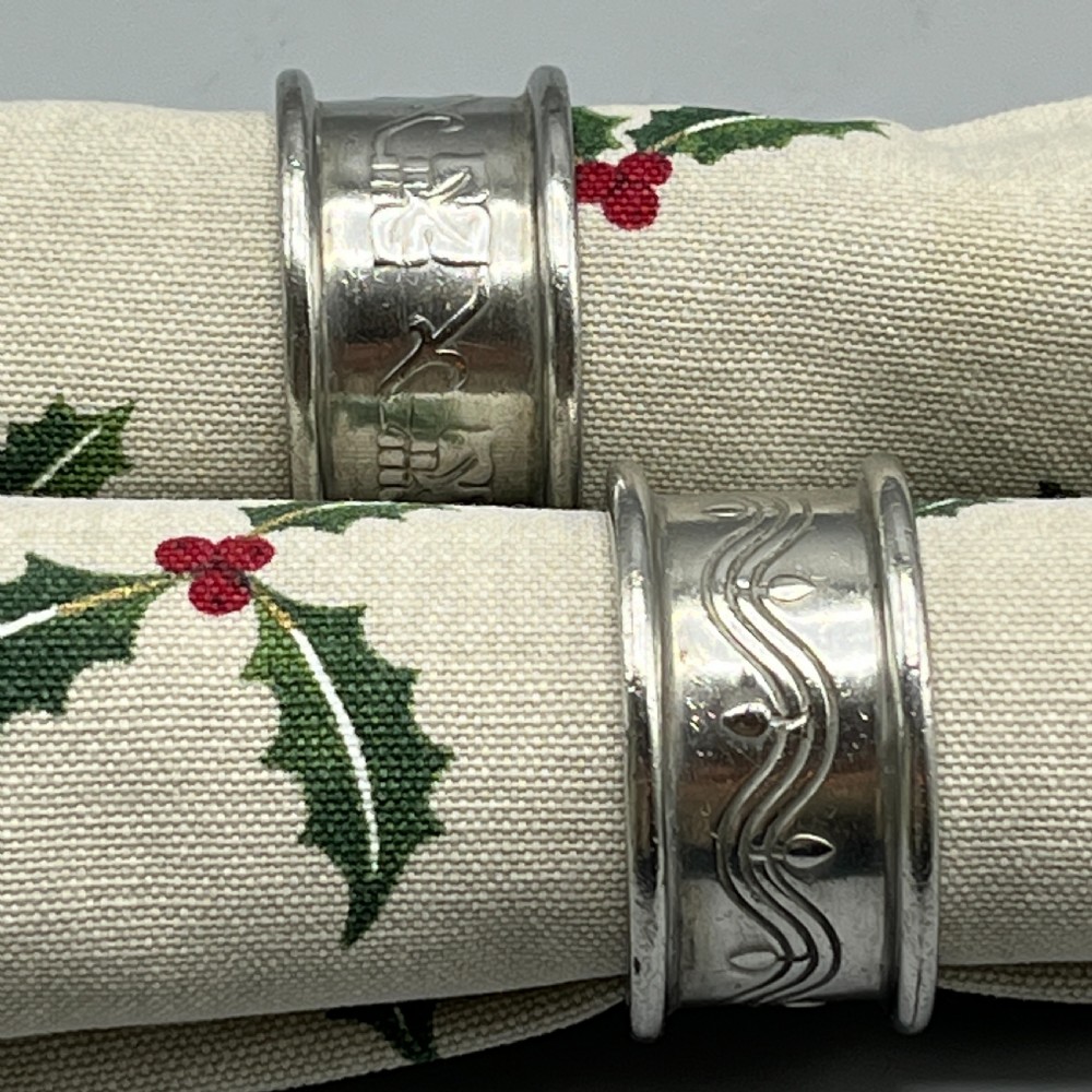 A pair of circular pewter napkin rings decorated with embossed Arts and Crafts stylised floral and tendril motifs. View II