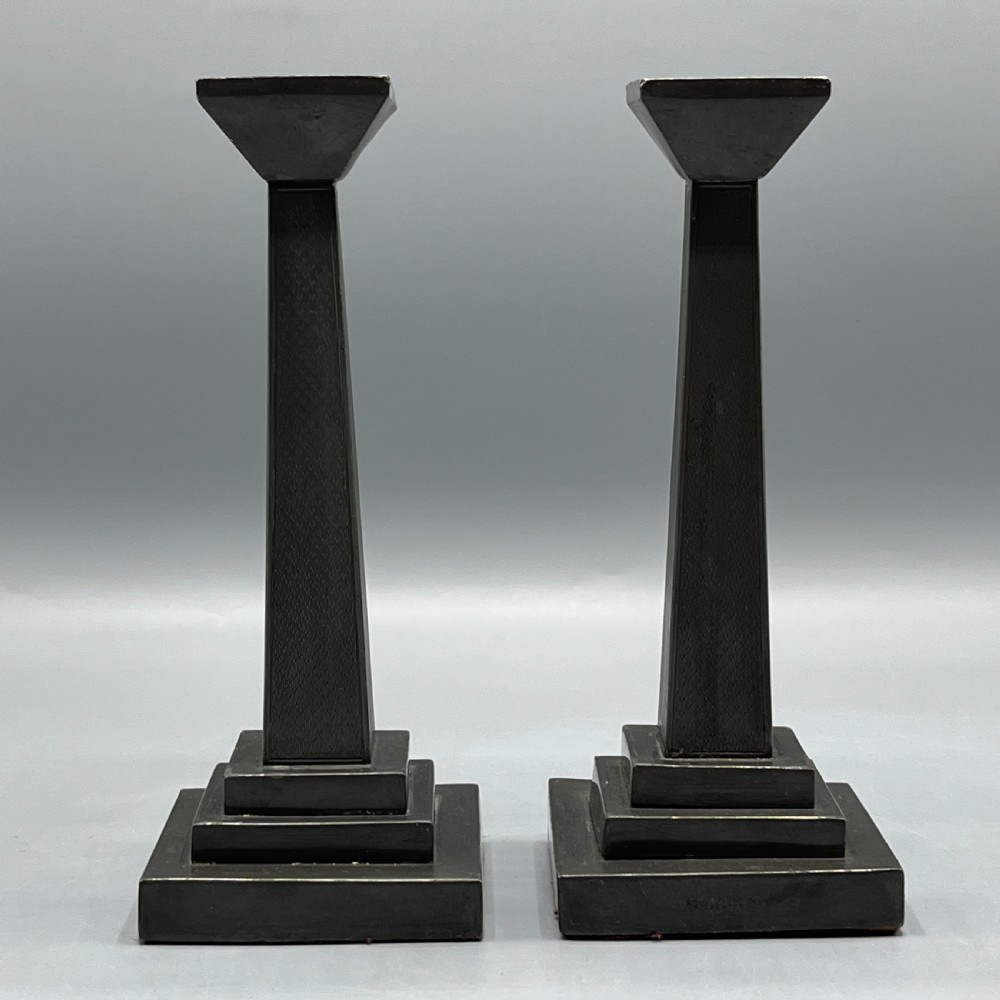 A pair of dark grey Art Deco pewter candlesticks featuring stepped square bases and tapered central columns. View II