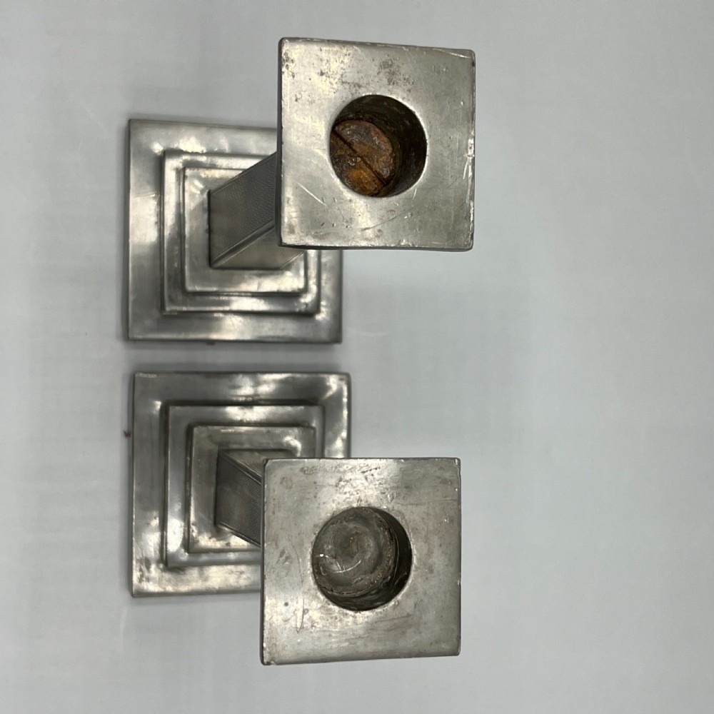 A pair of dark grey Art Deco pewter candlesticks featuring stepped square bases and tapered central columns. View VIII