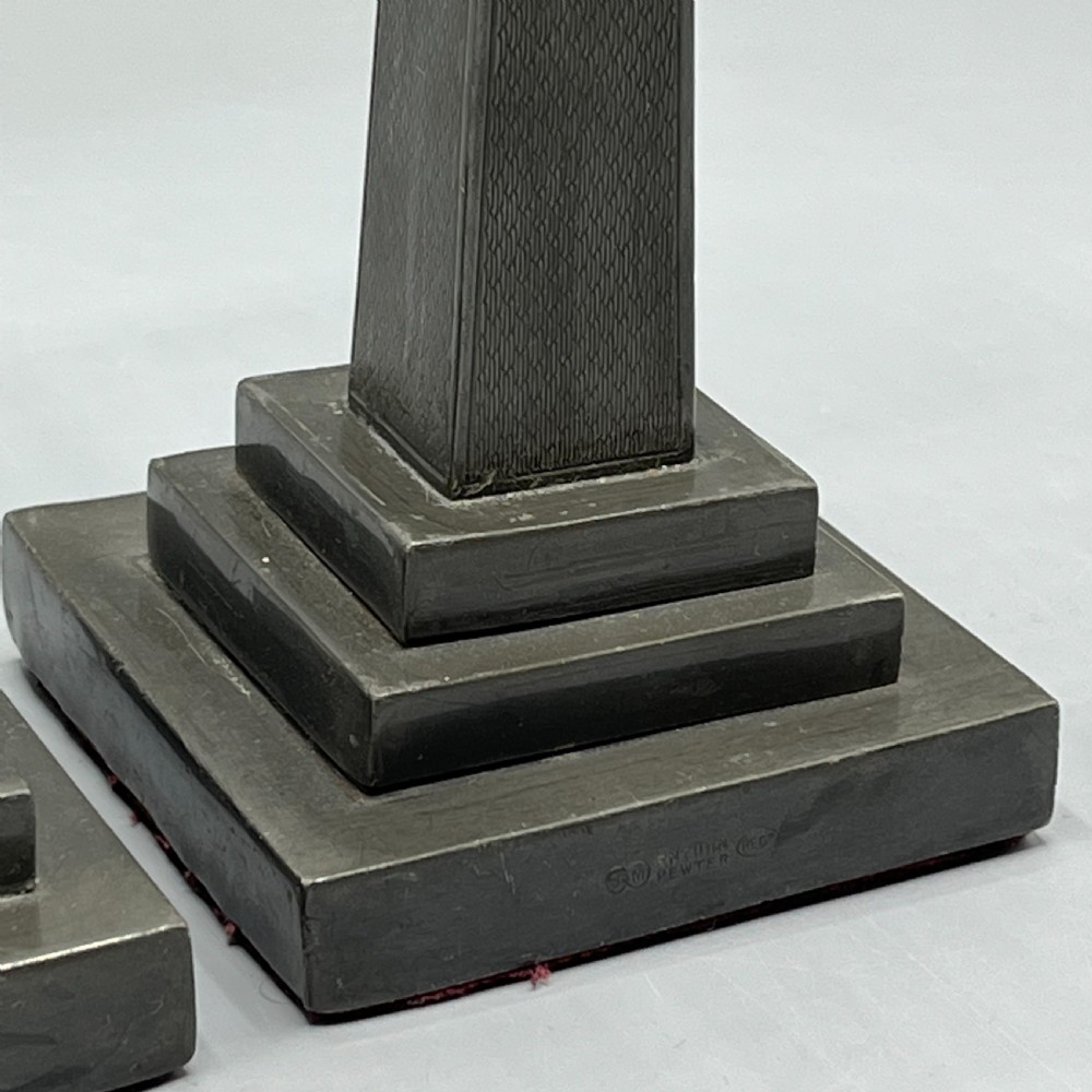 A pair of dark grey Art Deco pewter candlesticks featuring stepped square bases and tapered central columns. View XI