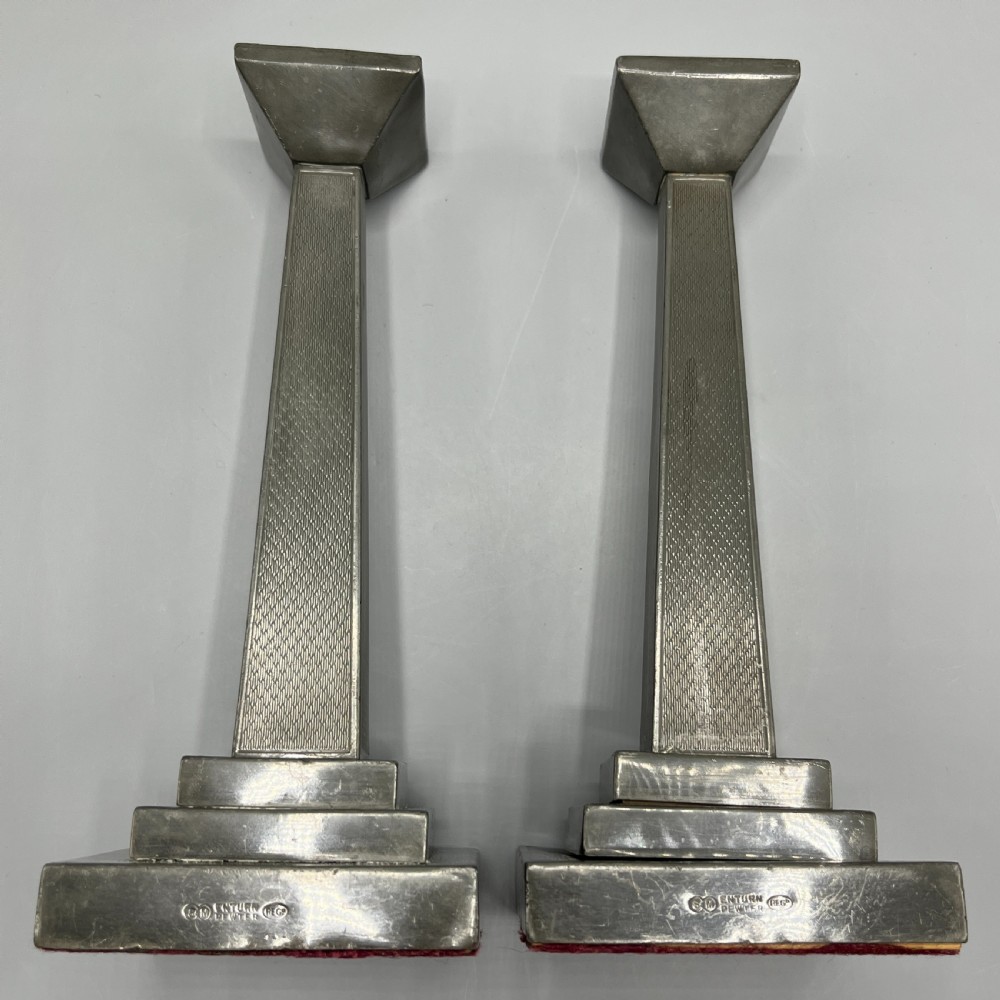 A pair of dark grey Art Deco pewter candlesticks featuring stepped square bases and tapered central columns. View XIII