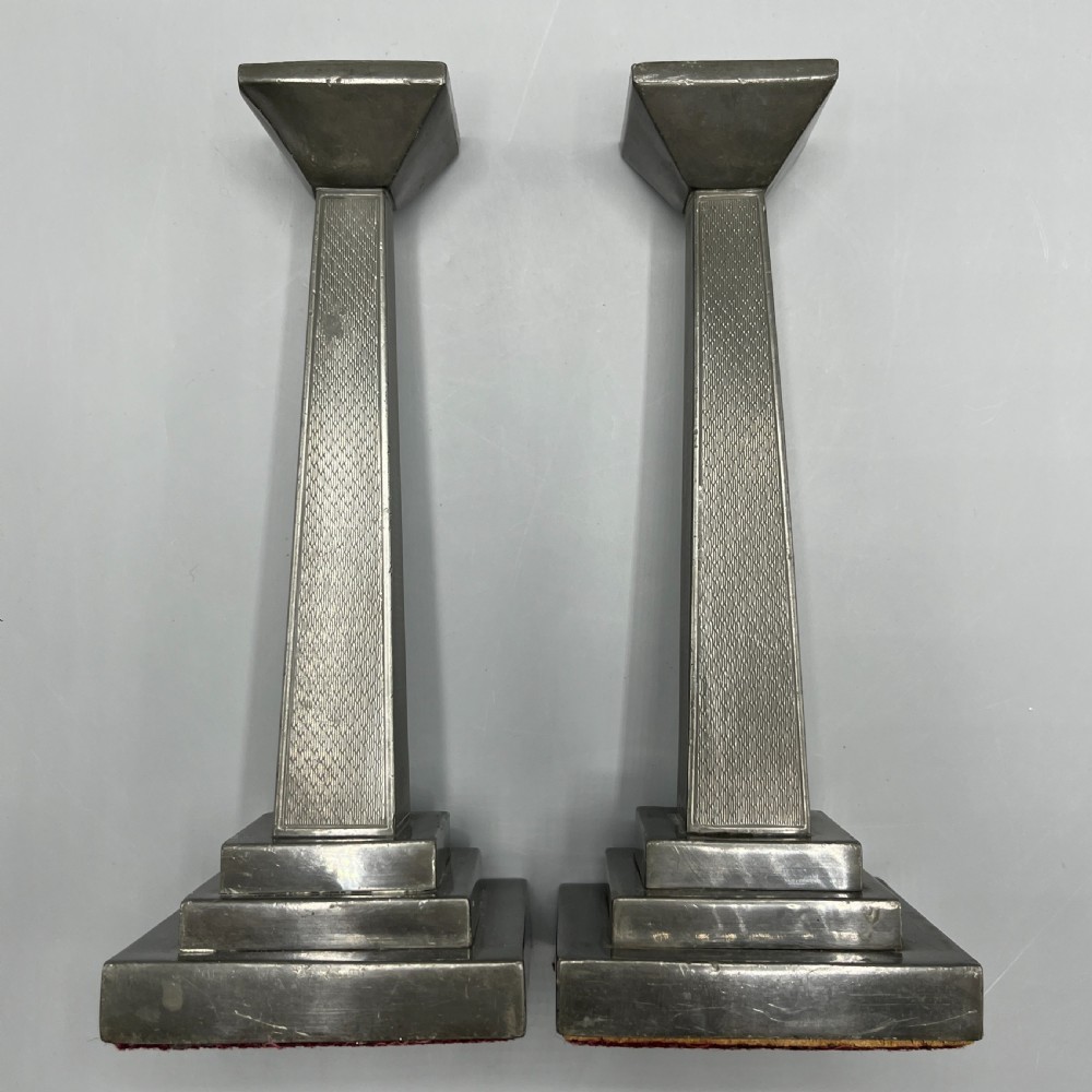 A pair of dark grey Art Deco pewter candlesticks featuring stepped square bases and tapered central columns. View XVII