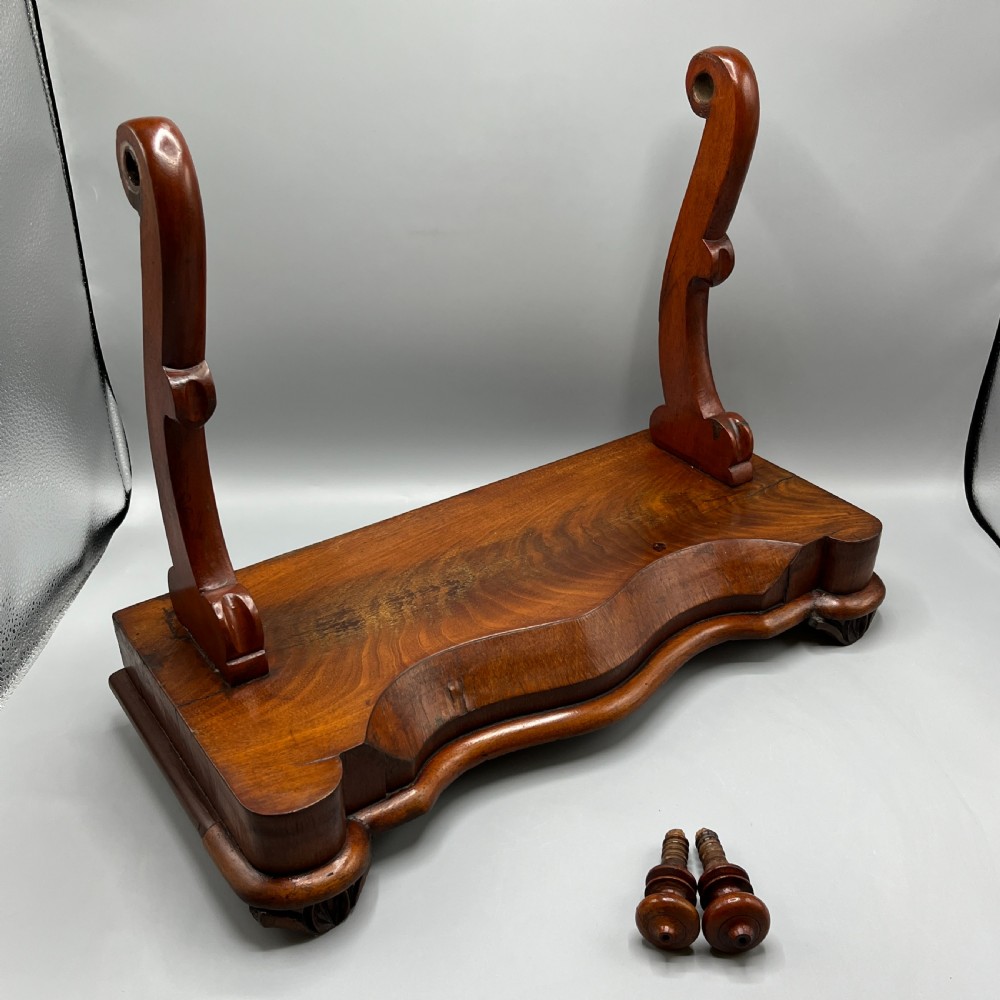 A Victorian mahogany dressing table mirror with an arched swivel frame and carved scroll uprights set on a serpentine base. View XVI