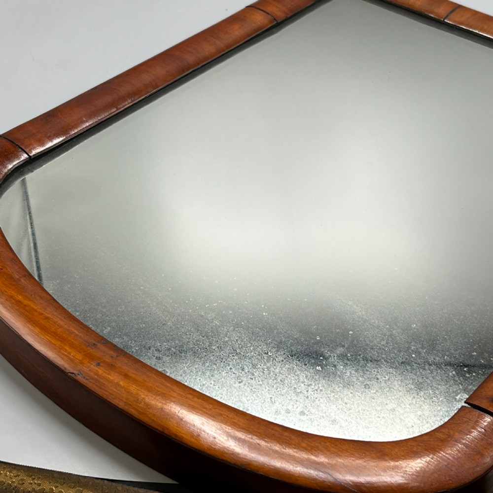 A Victorian mahogany dressing table mirror with an arched swivel frame and carved scroll uprights set on a serpentine base. View XXIII