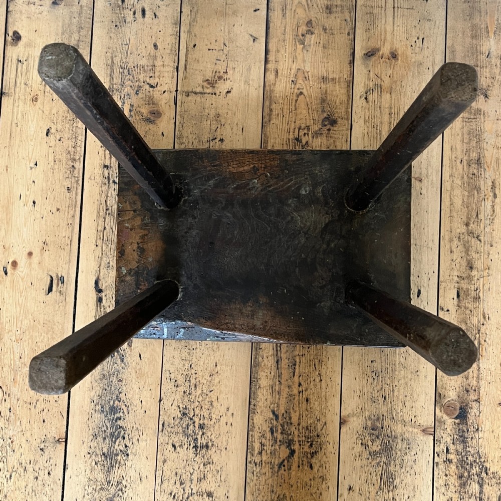 A rustic dark oak four-legged stool featuring a thick rectangular top with four visible circular wedged tenons and splayed faceted legs. View XX