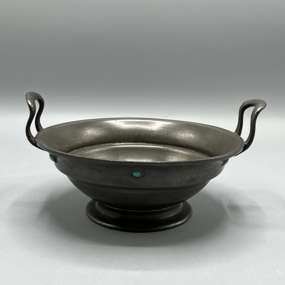 An Arts and Crafts pewter porringer bowl featuring twin raised handles, a pedestal base, and small turquoise cabochons set into the exterior rim. View II