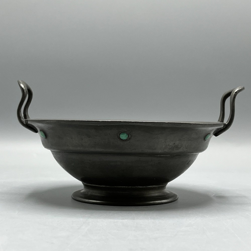 An Arts and Crafts pewter porringer bowl featuring twin raised handles, a pedestal base, and small turquoise cabochons set into the exterior rim. View III