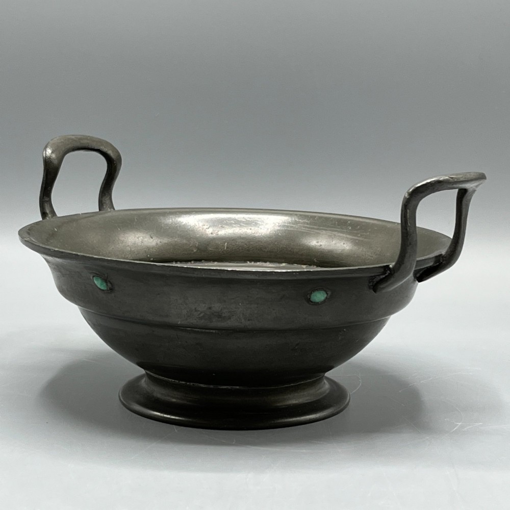 An Arts and Crafts pewter porringer bowl featuring twin raised handles, a pedestal base, and small turquoise cabochons set into the exterior rim. View IV