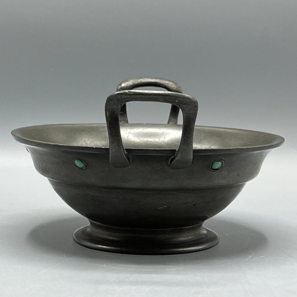 An Arts and Crafts pewter porringer bowl featuring twin raised handles, a pedestal base, and small turquoise cabochons set into the exterior rim. View VIII