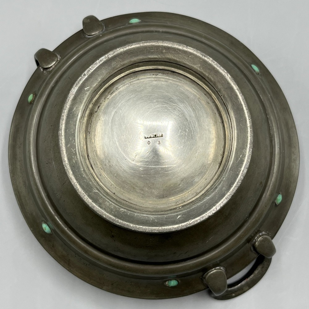 An Arts and Crafts pewter porringer bowl featuring twin raised handles, a pedestal base, and small turquoise cabochons set into the exterior rim. View XI