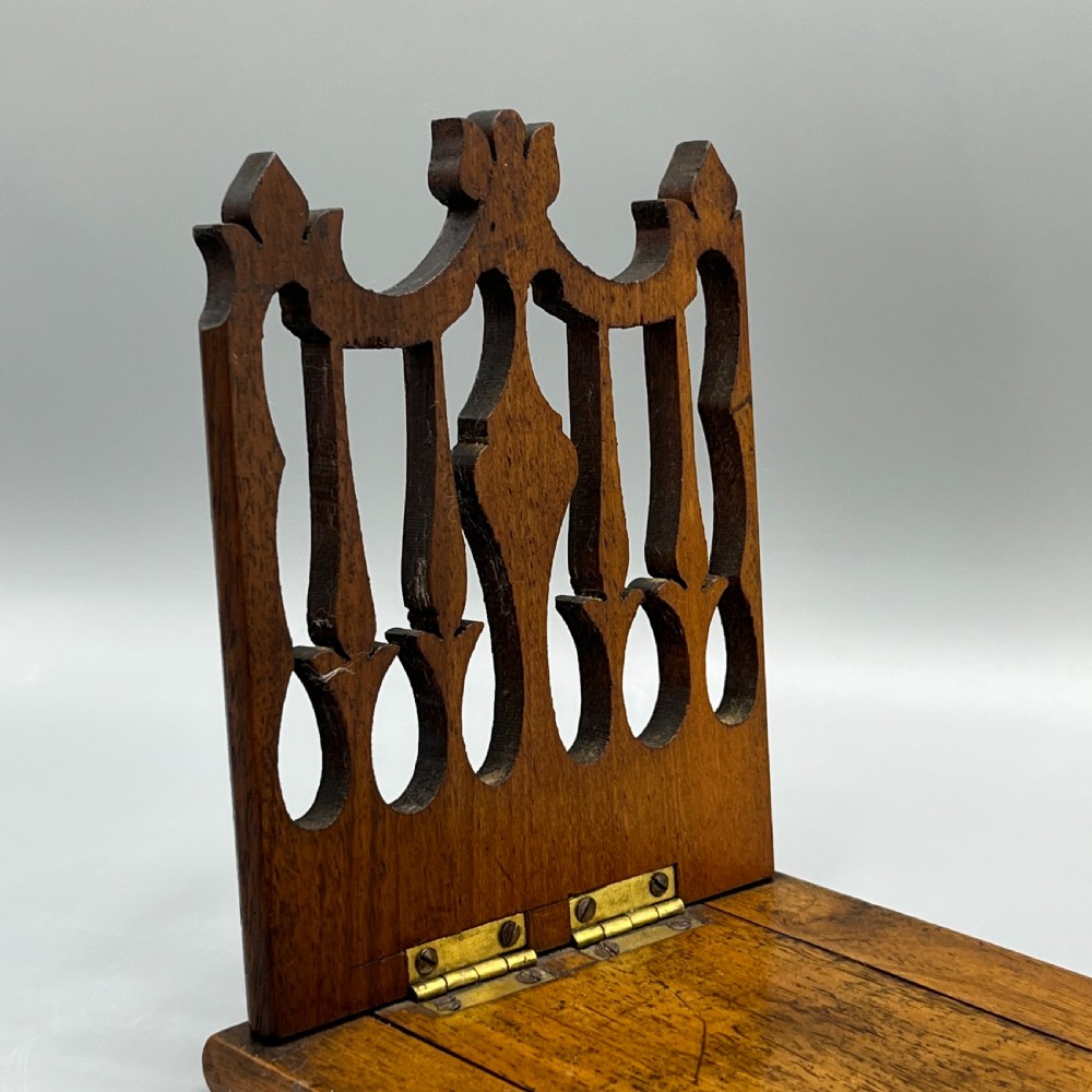 An Edwardian wooden extending book slide featuring carved pierced fretwork ends attached with brass hinges to a smooth base. View V