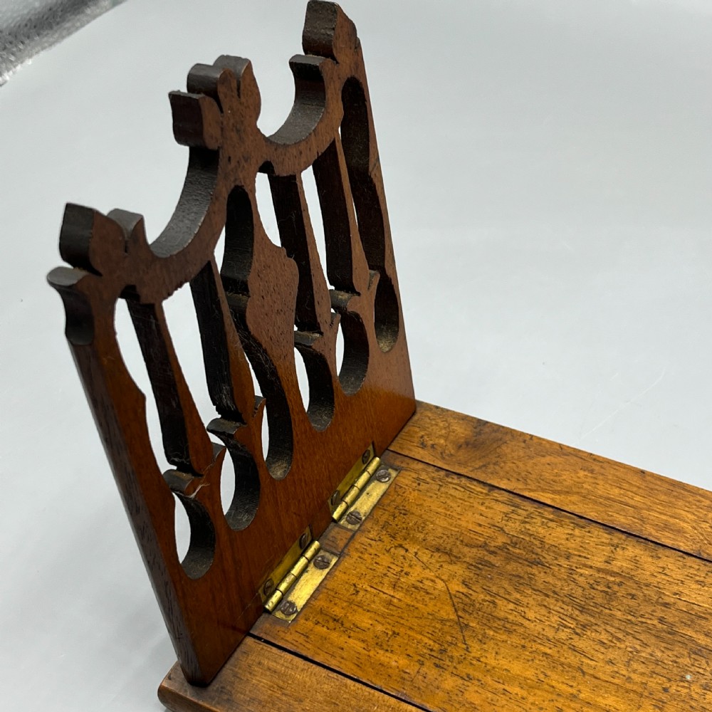 An Edwardian wooden extending book slide featuring carved pierced fretwork ends attached with brass hinges to a smooth base. View VIII