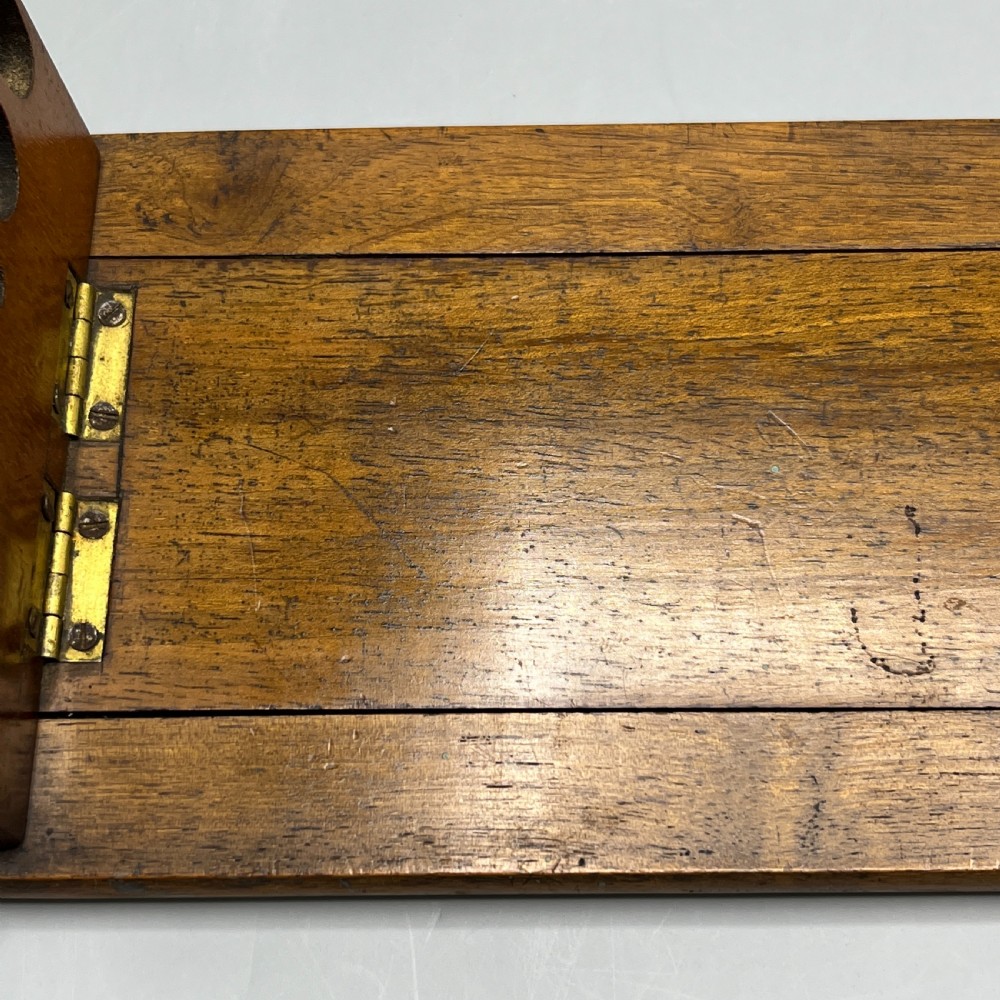 An Edwardian wooden extending book slide featuring carved pierced fretwork ends attached with brass hinges to a smooth base. View X