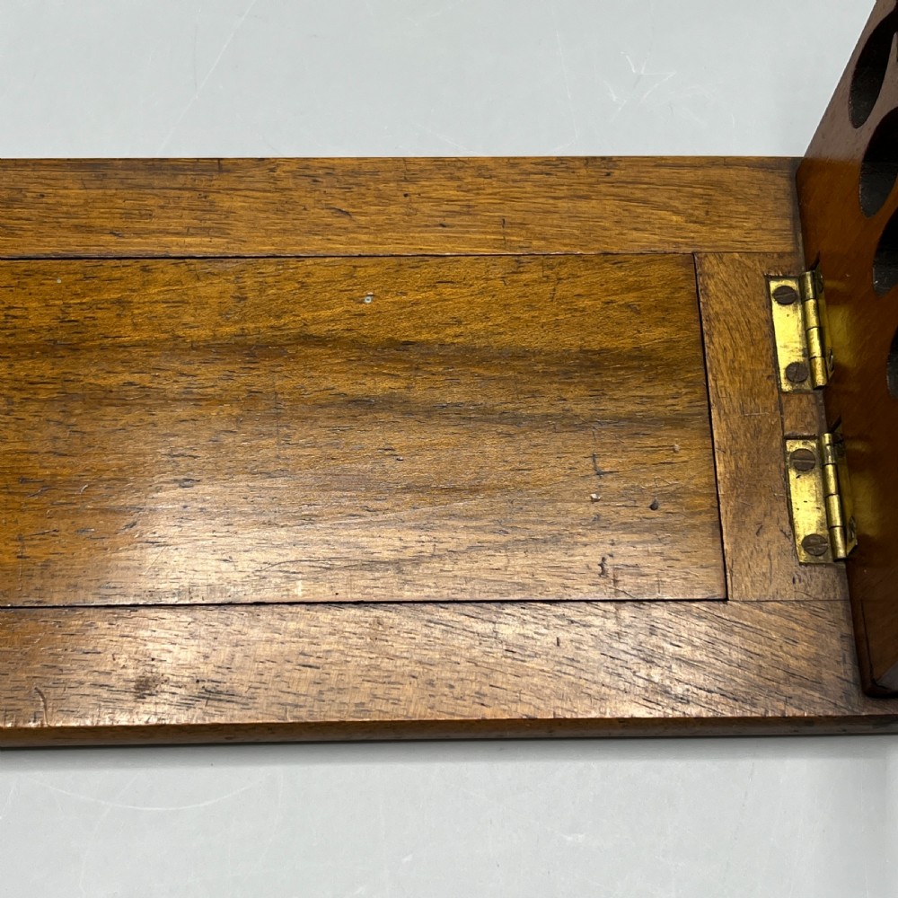 An Edwardian wooden extending book slide featuring carved pierced fretwork ends attached with brass hinges to a smooth base. View XI