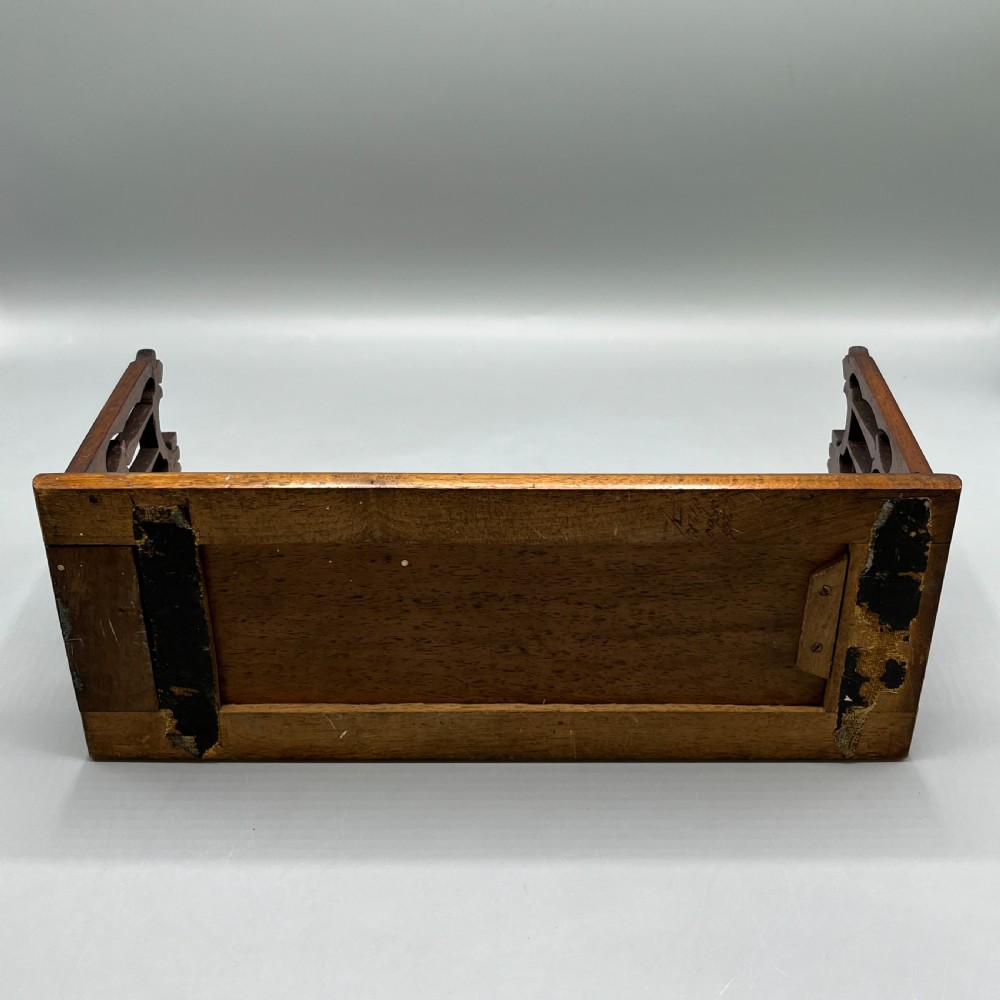 An Edwardian wooden extending book slide featuring carved pierced fretwork ends attached with brass hinges to a smooth base. View XII