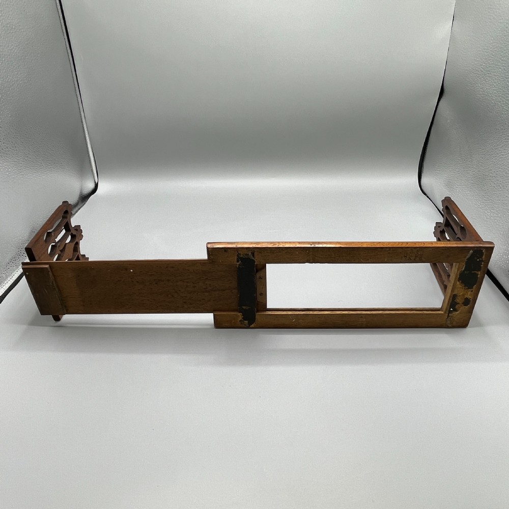 An Edwardian wooden extending book slide featuring carved pierced fretwork ends attached with brass hinges to a smooth base. View XIII