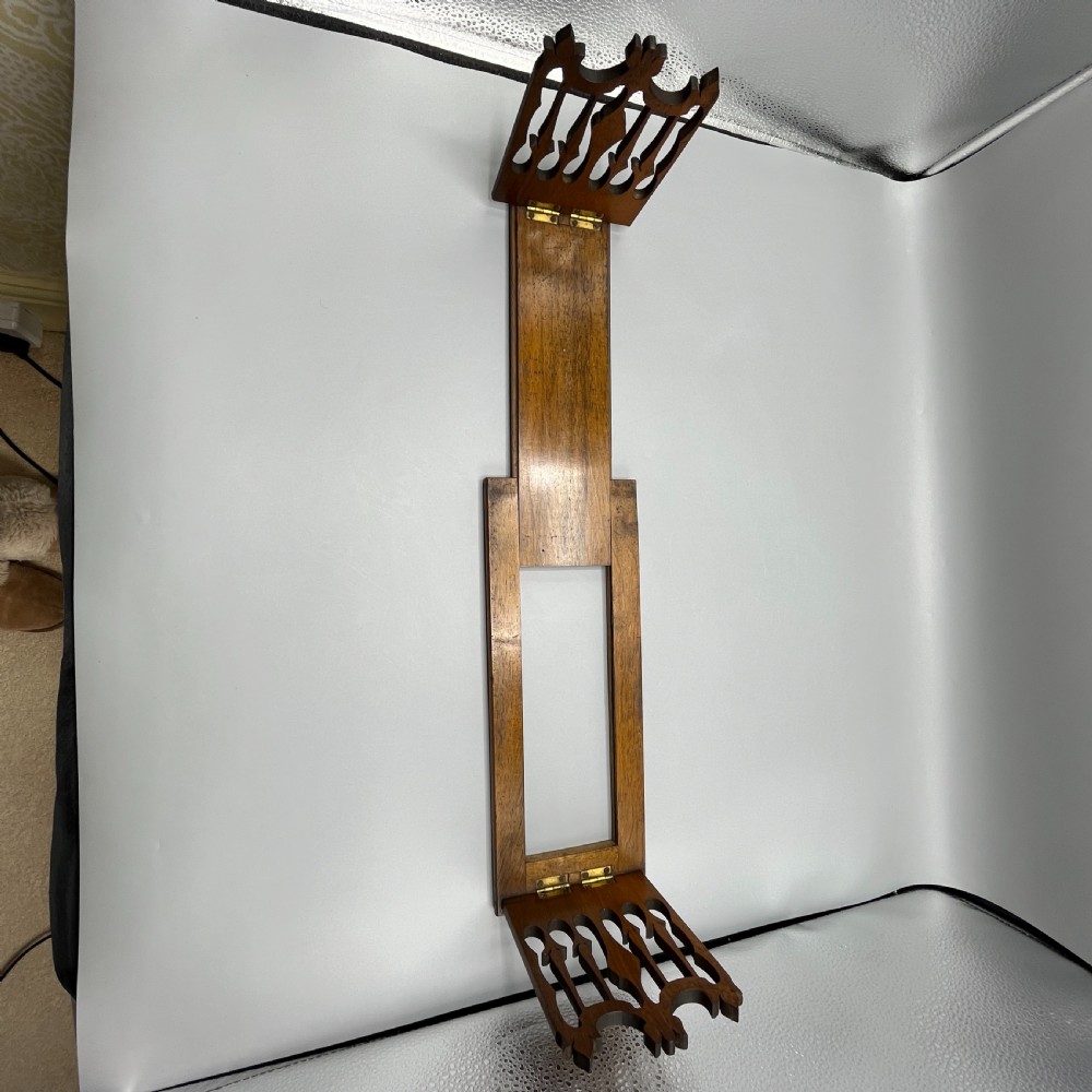 An Edwardian wooden extending book slide featuring carved pierced fretwork ends attached with brass hinges to a smooth base. View XIV