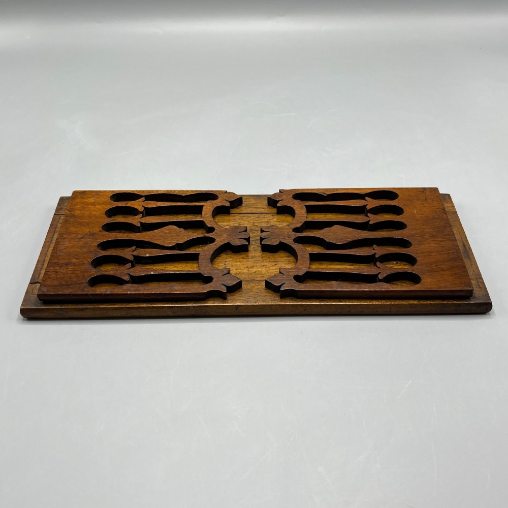 An Edwardian wooden extending book slide featuring carved pierced fretwork ends attached with brass hinges to a smooth base. View XV