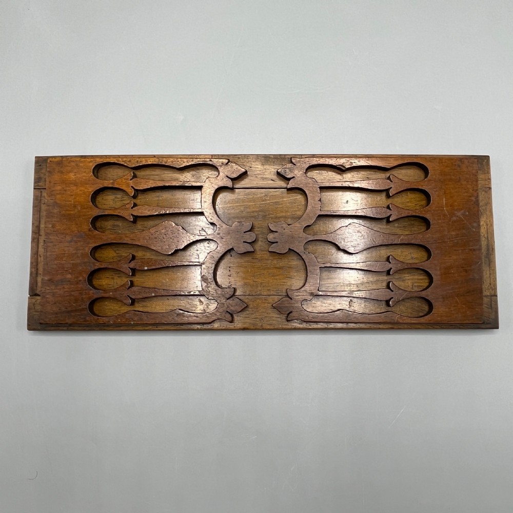 An Edwardian wooden extending book slide featuring carved pierced fretwork ends attached with brass hinges to a smooth base. View XVI