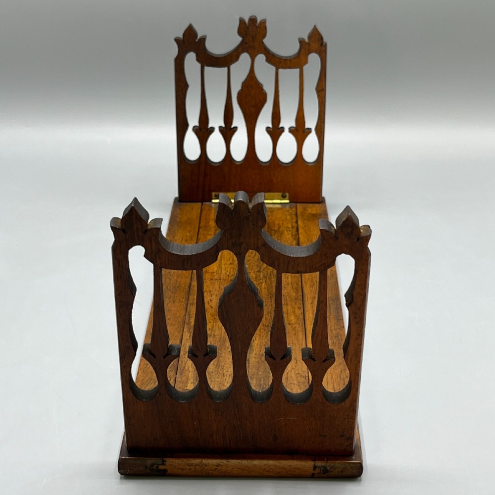 An Edwardian wooden extending book slide featuring carved pierced fretwork ends attached with brass hinges to a smooth base. View XVII