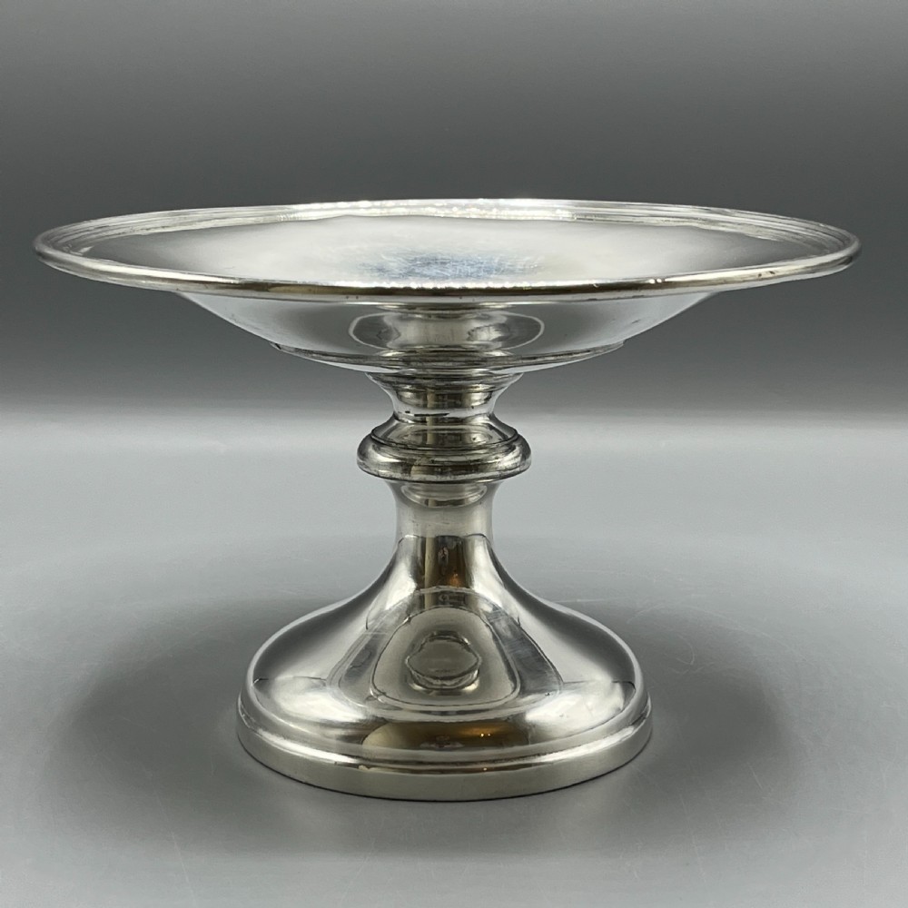 A circular silver-plated tazza dish with a shallow tray resting on a moulded pedestal stem and flared base. View II