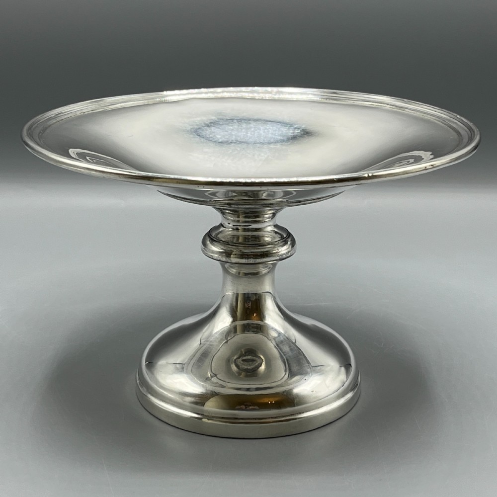 A circular silver-plated tazza dish with a shallow tray resting on a moulded pedestal stem and flared base. View III