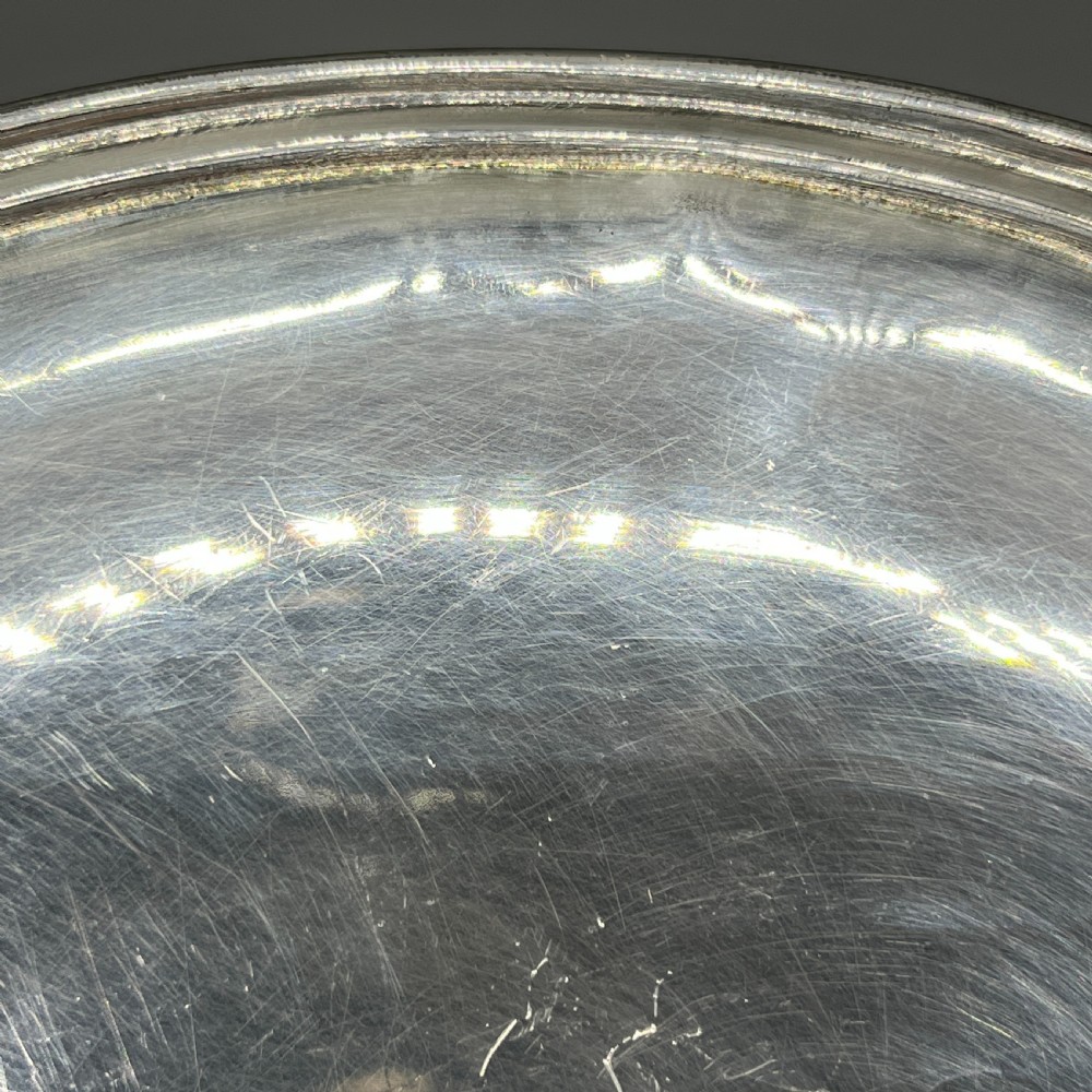 A circular silver-plated tazza dish with a shallow tray resting on a moulded pedestal stem and flared base. View VII