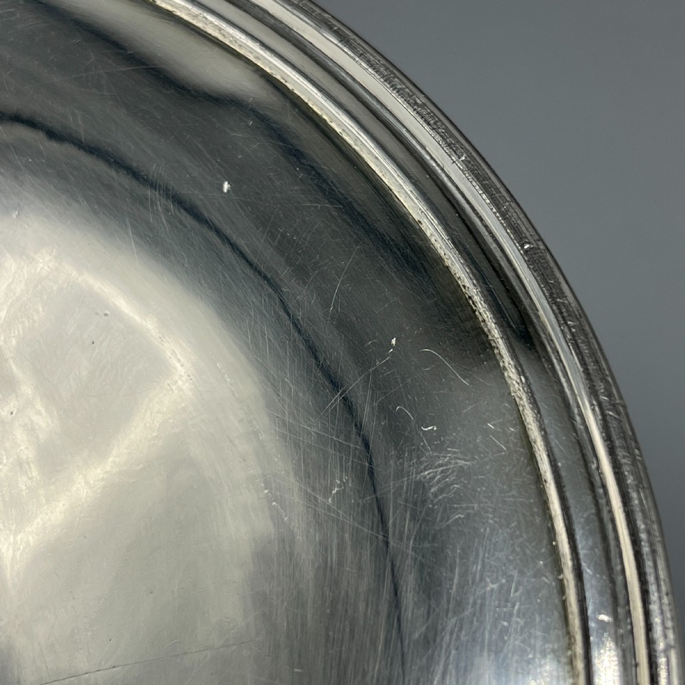 A circular silver-plated tazza dish with a shallow tray resting on a moulded pedestal stem and flared base. View VIII