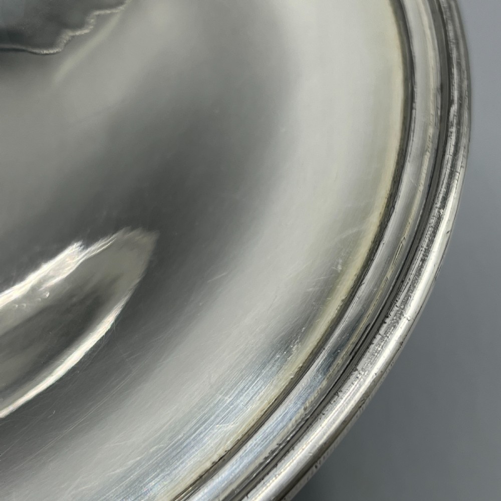 A circular silver-plated tazza dish with a shallow tray resting on a moulded pedestal stem and flared base. View IX