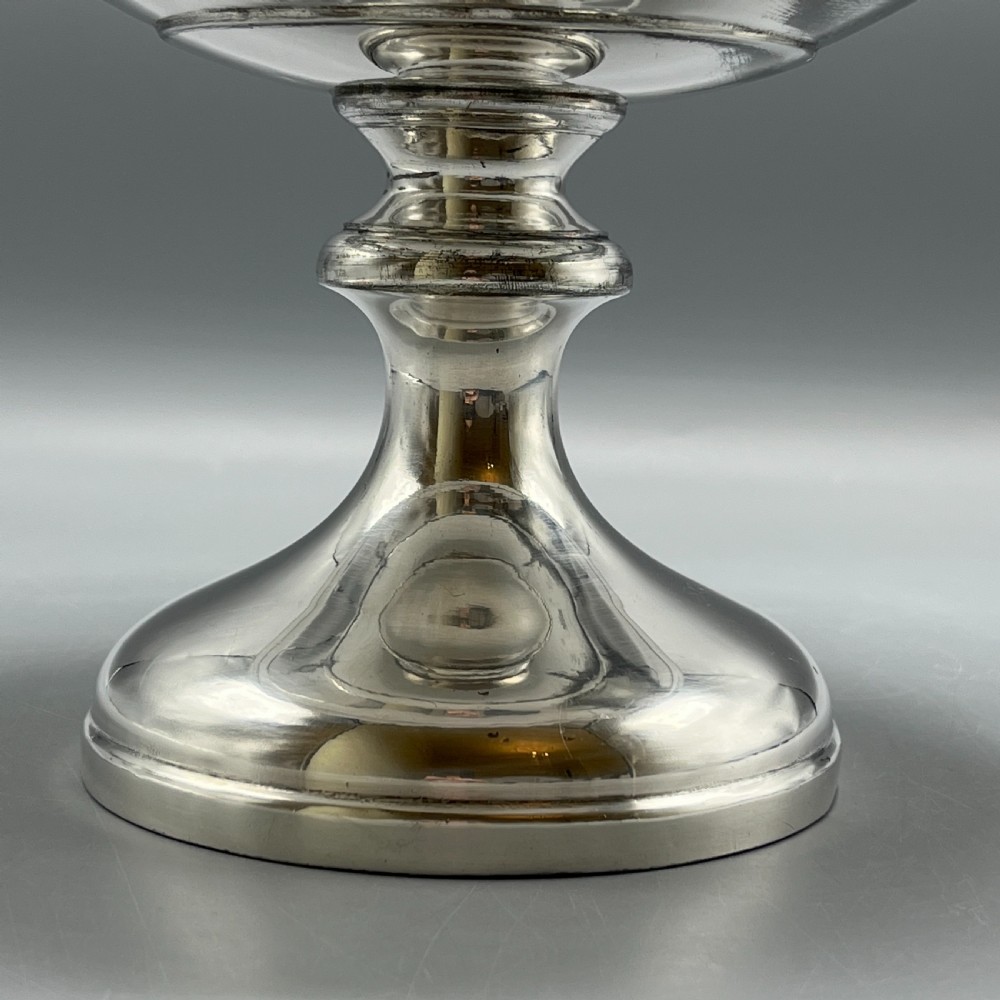 A circular silver-plated tazza dish with a shallow tray resting on a moulded pedestal stem and flared base. View XI