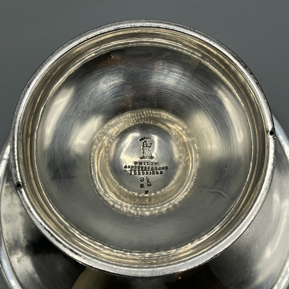 A circular silver-plated tazza dish with a shallow tray resting on a moulded pedestal stem and flared base. View XIII
