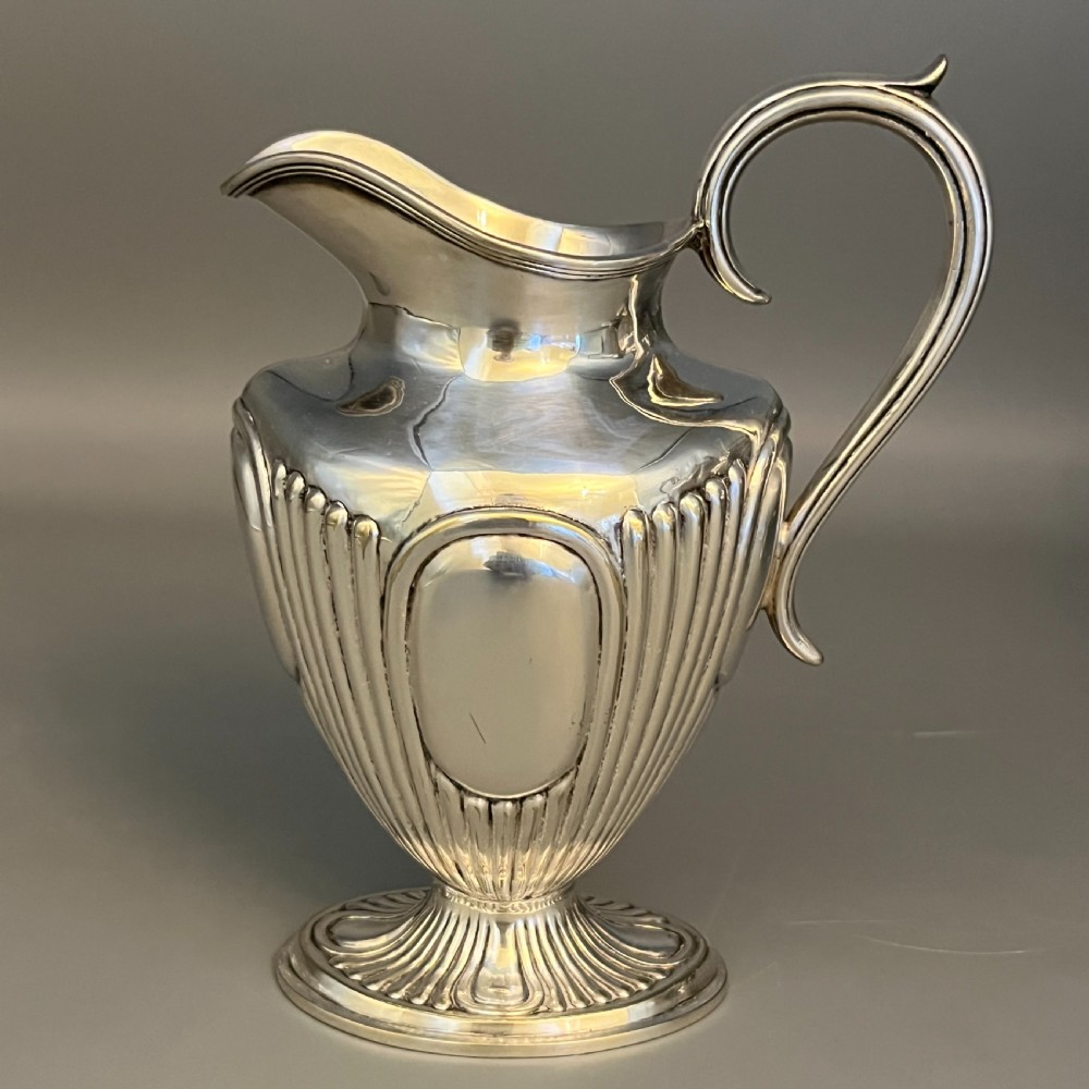 A four-piece Victorian silver-plated tea and coffee set featuring a teapot, coffee pot, sugar bowl, and cream jug with fluted bodies and pedestal bases. View IV