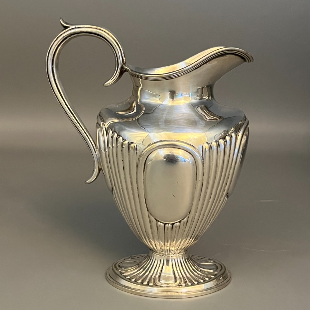 A four-piece Victorian silver-plated tea and coffee set featuring a teapot, coffee pot, sugar bowl, and cream jug with fluted bodies and pedestal bases. View V