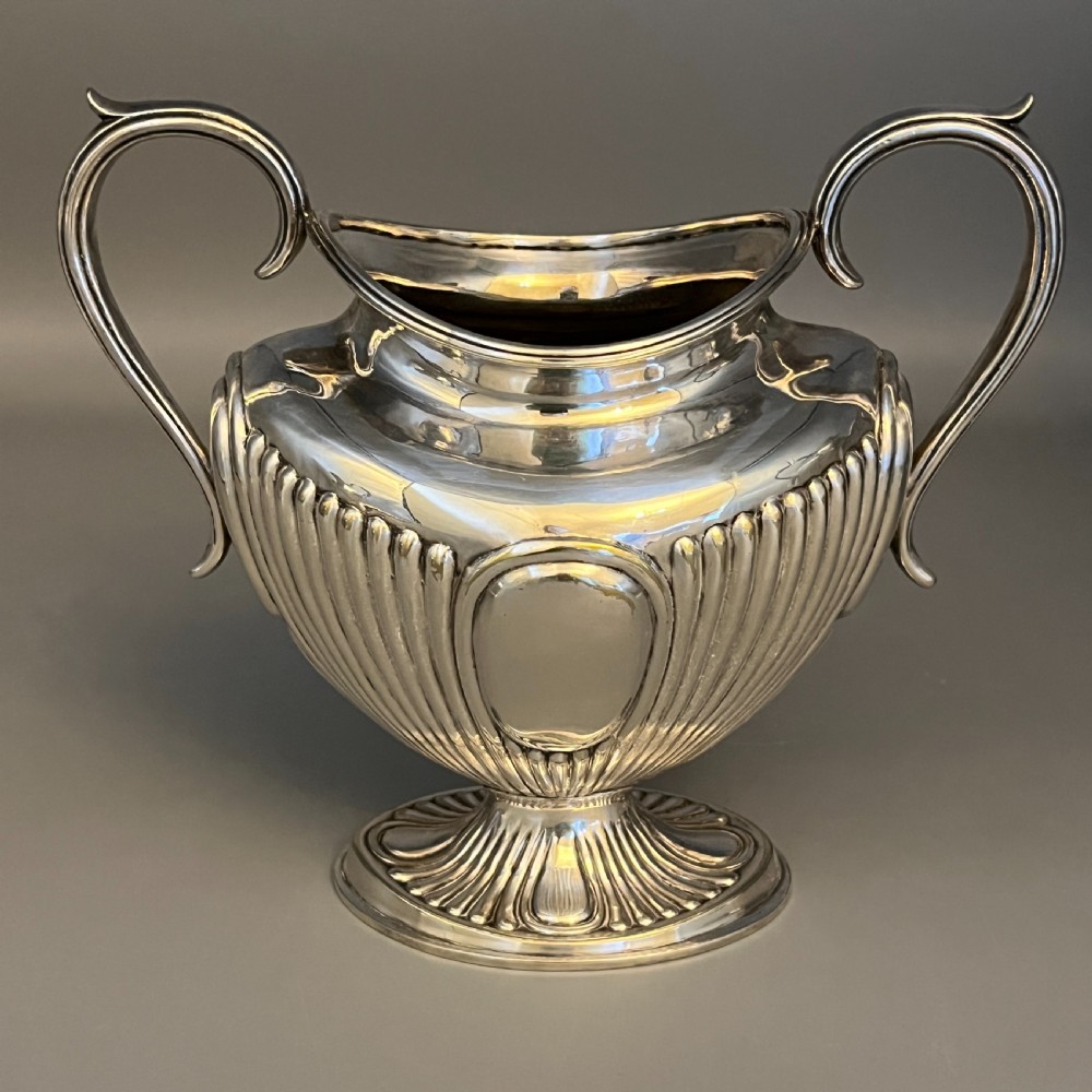 A four-piece Victorian silver-plated tea and coffee set featuring a teapot, coffee pot, sugar bowl, and cream jug with fluted bodies and pedestal bases. View VII