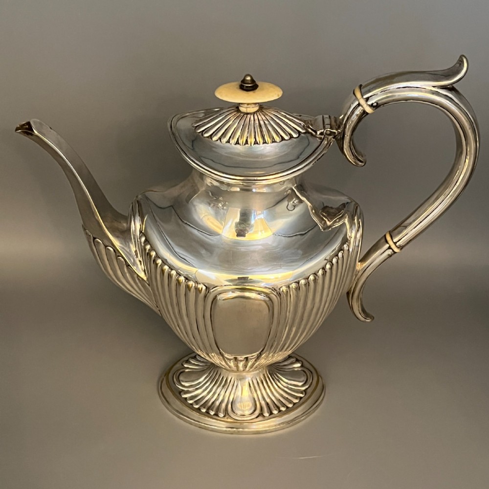 A four-piece Victorian silver-plated tea and coffee set featuring a teapot, coffee pot, sugar bowl, and cream jug with fluted bodies and pedestal bases. View VIII