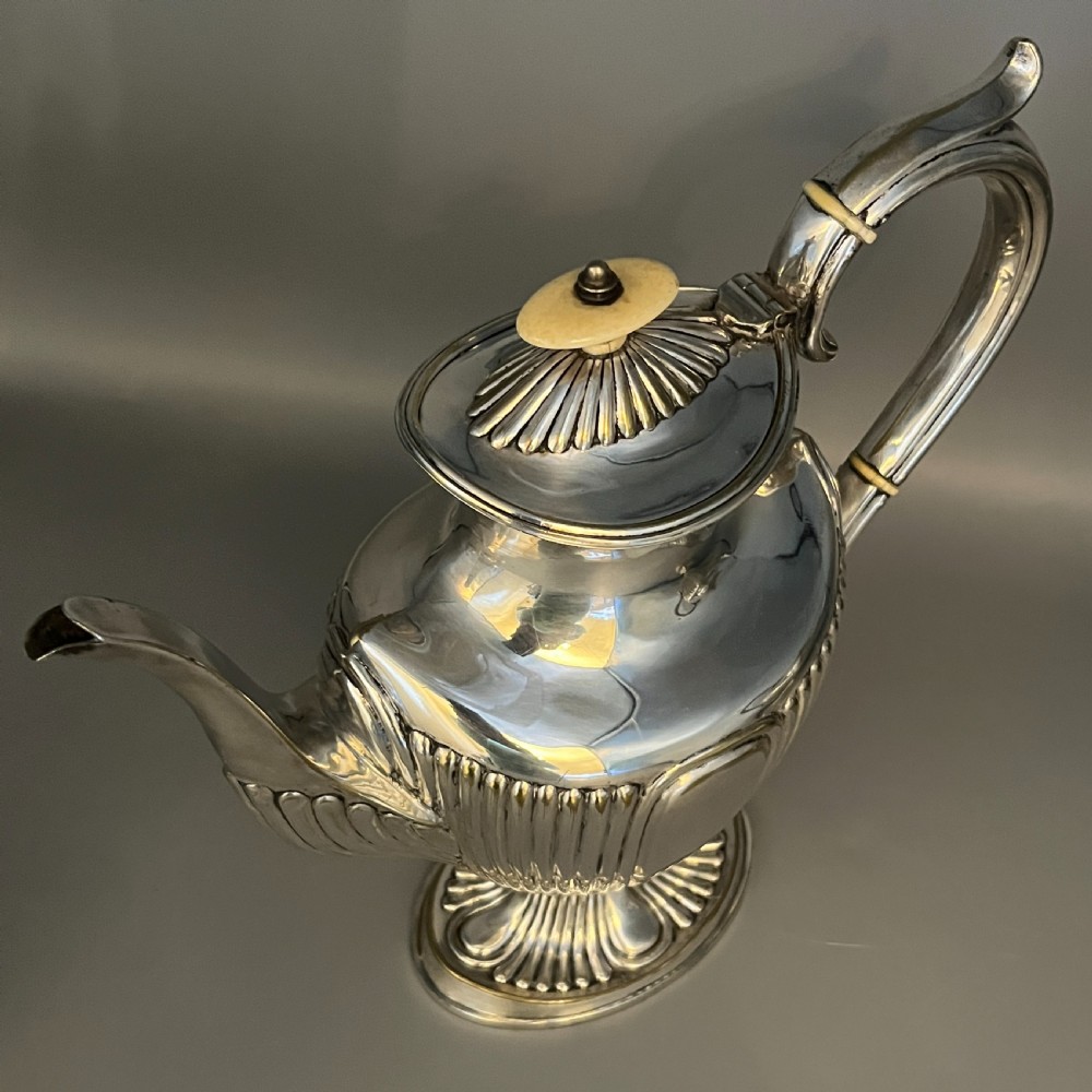 A four-piece Victorian silver-plated tea and coffee set featuring a teapot, coffee pot, sugar bowl, and cream jug with fluted bodies and pedestal bases. View IX