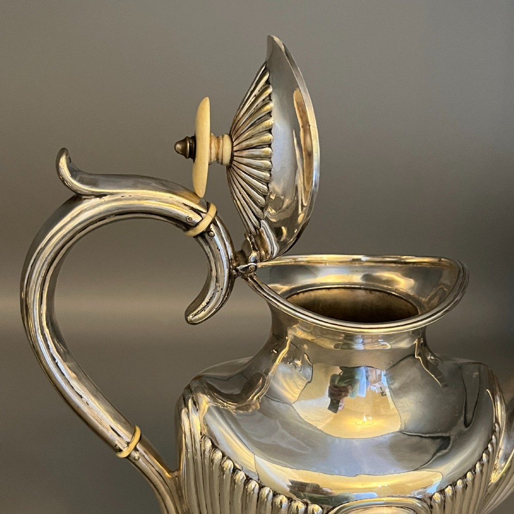 A four-piece Victorian silver-plated tea and coffee set featuring a teapot, coffee pot, sugar bowl, and cream jug with fluted bodies and pedestal bases. View XI