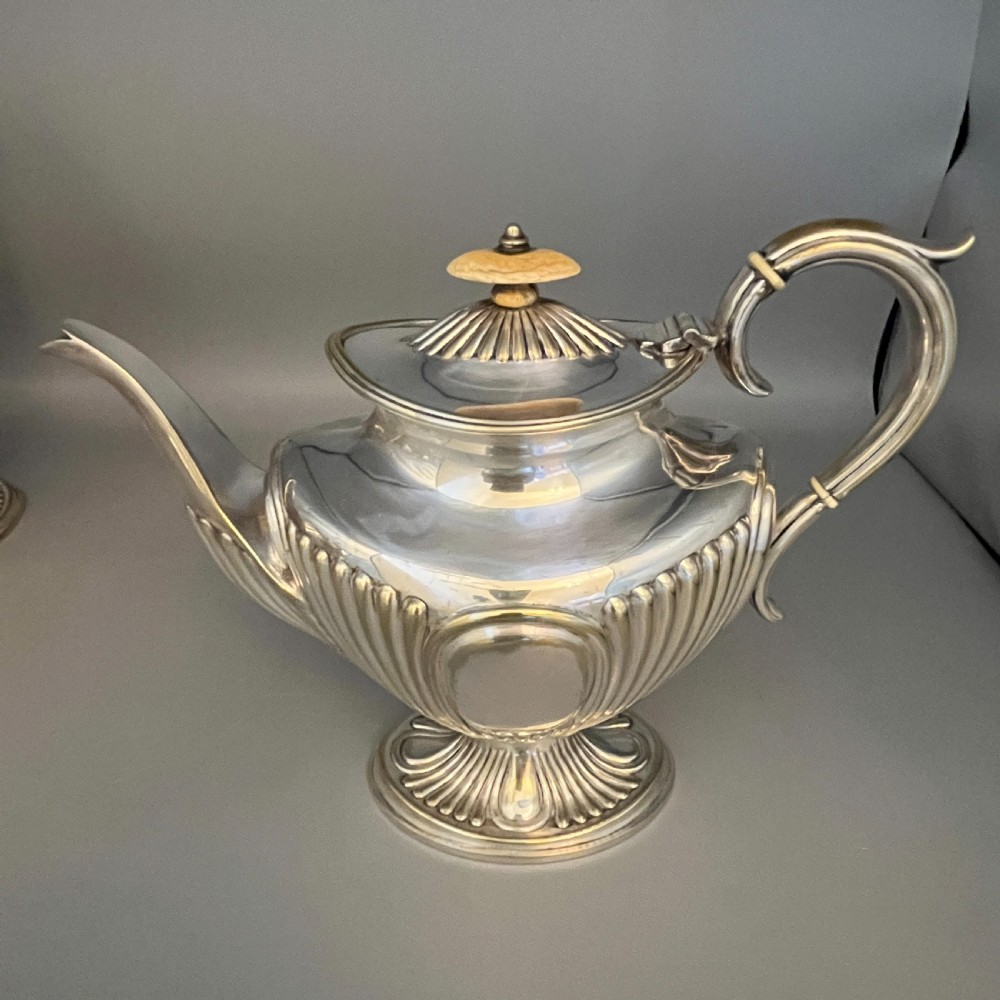 A four-piece Victorian silver-plated tea and coffee set featuring a teapot, coffee pot, sugar bowl, and cream jug with fluted bodies and pedestal bases. View XII