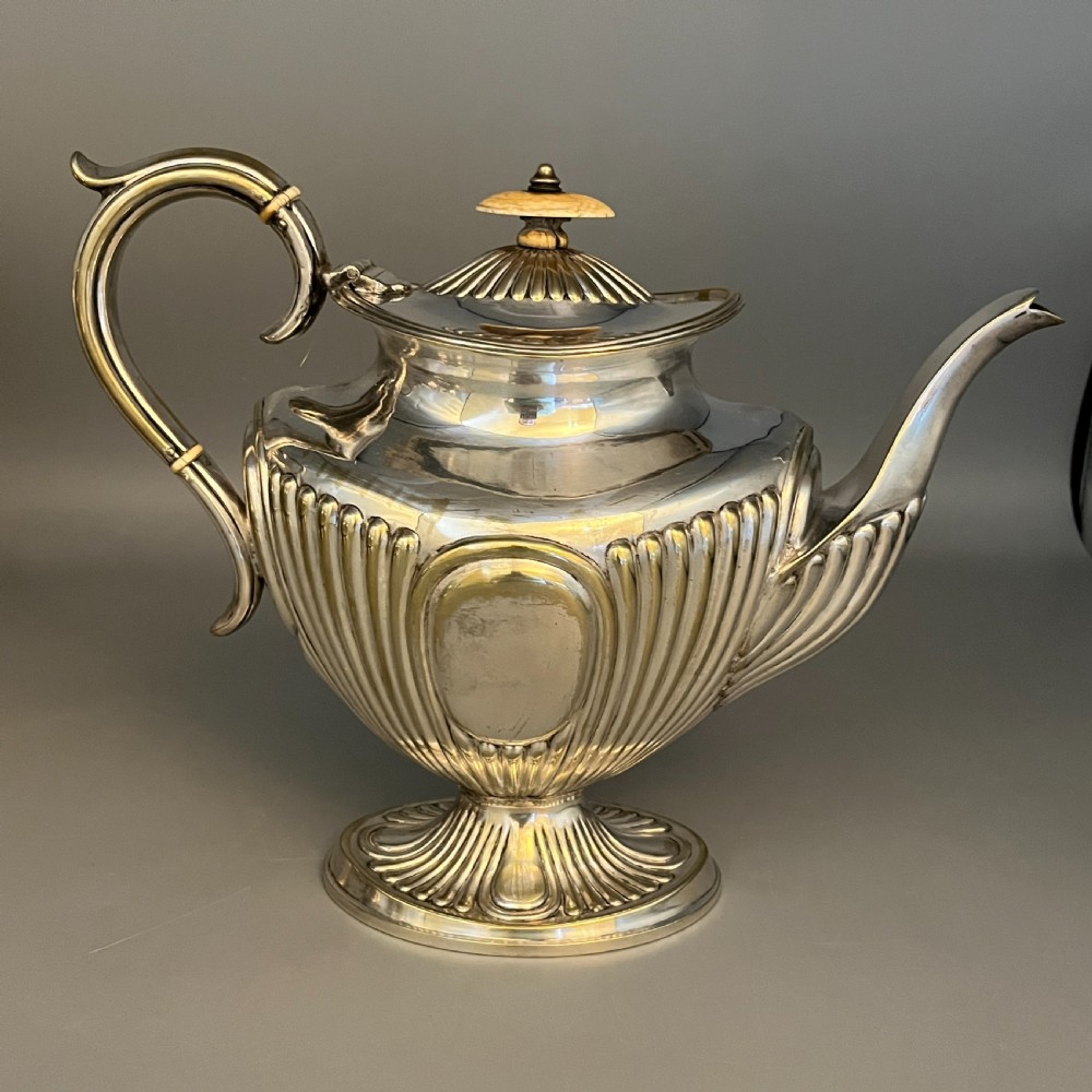 A four-piece Victorian silver-plated tea and coffee set featuring a teapot, coffee pot, sugar bowl, and cream jug with fluted bodies and pedestal bases. View XVI