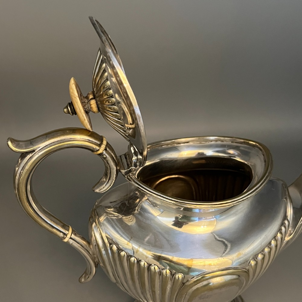 A four-piece Victorian silver-plated tea and coffee set featuring a teapot, coffee pot, sugar bowl, and cream jug with fluted bodies and pedestal bases. View XVII