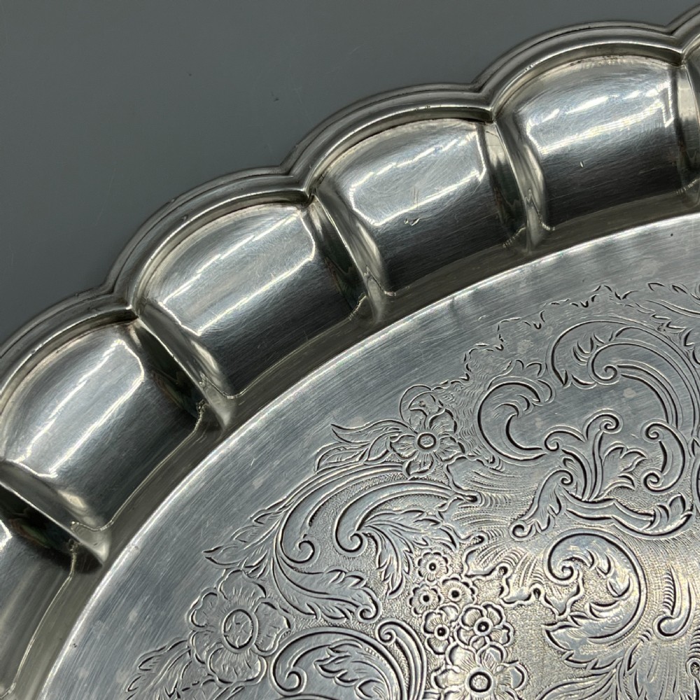 A large oval silver plated serving tray featuring twin scroll handles, a scalloped rim, and chased foliage patterns across the flat interior. View VIII