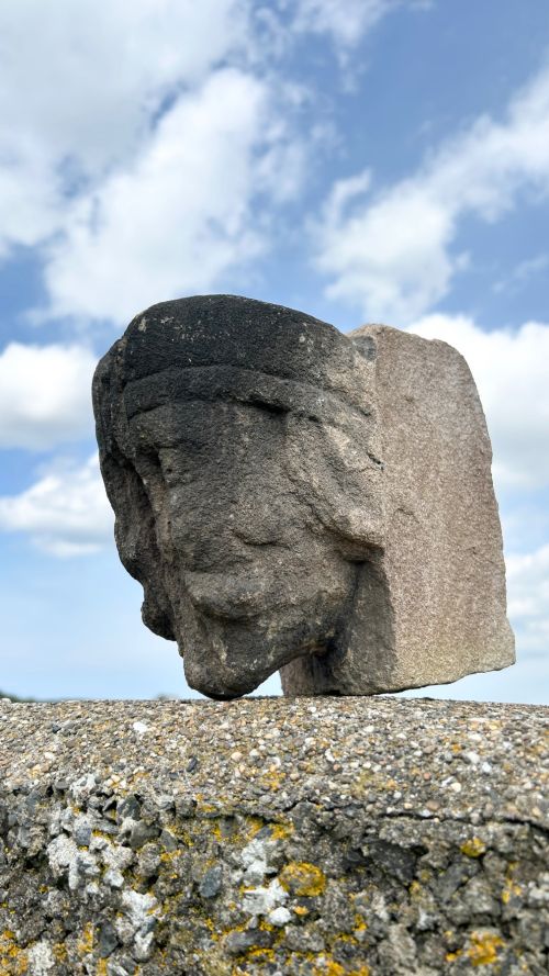 fig 2. A weathered 17th-century carved stone head fragment with defined facial features and visible surface erosion.