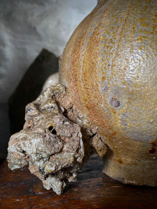 fig 1. A salt-glazed stoneware Bartmann jug featuring a moulded bearded face mask on the neck and a round medallion crest on the globular body.