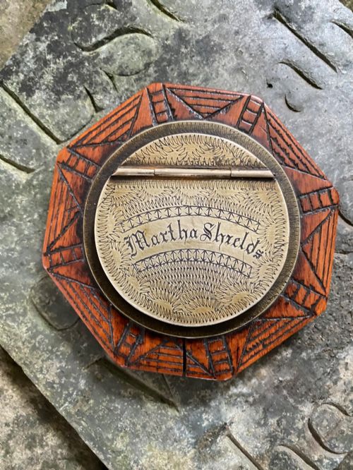 fig 1. An early nineteenth-century octagonal carved wooden treen snuff box featuring an engraved brass hinged lid inscribed with the name Martha Shields.